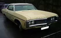 Chevrolet Impala Convertible aus dem Jahr 1969. Im Modelljahr 1969 bot Chevrolet neben den sportlichen Typen Camaro und Corvette zwei weitere Modellreihen an: Den Impala und den etwas höherpreisigen Caprice. Beide Modellreihen waren mit folgenden Motorisierungen lieferbar: Sechszylinderreihenmotor mit 250 cui und 155 PS, sowie vier V8-Motoren mit 327 cui/235 PS, 350 cui/255 PS oder 300 PS, 396 cui/265 PS und sogar 427 cui/335 PS oder 390 PS. Das gezeigte Cabriolet im Farbton butternut yellow, ist mit dem kleinsten  Achtender = 327 cui = 5358 cm³  ausgerüstet. Besucherparkplatz der Düsseldorfer Classic Remise am 26.02.2024.