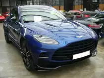 Aston Martin DBX707, erstmalig zugelassen im Mai 2023 im Farbton ion blue . Der Aston Martin DBX707 ist momentan der leistungsstärkste Luxus-SUV der weltweit zu kaufen ist. Der V8-Motor aus Leichtmetall hat einen Hubraum von 3982 cm³ und ist mit Twin-Turbolader versehen. Der Motor leistet, wie es aus der Typenbezeichnung bereits erkennbar ist, 707 PS. Diese Motorleistung verhilft dem SUV zu einer Höchstgeschwindigkeit von 310 km/h. Classic Remise Düsseldorf am 26.02.2024.