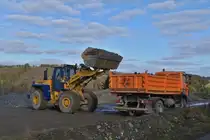 Hanomag Komatsu 60E, belädt einen LKW mit Schotter. 01.2024