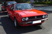 Lancia Beta Spider im Farbton rosso capanelle. Auf der Basis des bereits 1974 präsentierten Lancia Beta Coupe, brachte die Marke aus Turin zwei Jahre später den formschönen Beta Spider auf den Markt. Das Modell war in etlichen Motorisierungen lieferbar. 1982 wurde die Produktion eingestellt. Es gab Vierzylinderreihenmotoren mit 1.3l mit 82 PS, 1.6l mit 100 PS, 1.8l mit 110 PS, 2.0l mit 115 PS oder 119 PS, 2.0l iniezione eletronica mit 122 PS und den 2.0l Volumex mit 135 PS. Lediglich das  cavallo rampante  auf dem Kühlergrill ist ein wenig fehl am Platz.  Forza Italia  = Oldtimertreffen für italienische Fahrzeuge am 30.05.2024 an Mo´s Bikertreff in Krefeld.