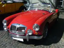 Der MG A kam 1955 auf den Markt und war als Roadster und geschlossenes Coupe lieferbar. Von den über 101.000 hergestellten Autos vom Typ MG A waren ca. 91% Roadster und nur 9% Coupes. Der gezeigte MG A 1600 MK2 kam 1961 auf den Markt. Er war optisch durch einen leicht geänderten Kühlergrill und die Heckleuchten des Morris Mini, die horizontal unterhalb der Kofferraumhaube verbaut waren, zu erkennen. Der Vierzylinderreihenmotor war in der MK2-Version nochmals auf einen Hubraum von 1622 cm³ aufgebohrt worden. und leistete nun 94 PS. 10. Borbecker Classic Day am 09.06.2024 in Essen-Borbeck.