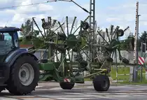 Schwader vom Hersteller KRONE Typ Krone Swadro 1400 als Hänger am 12.06.24 Bahnübergang Bahnhof Rodleben.