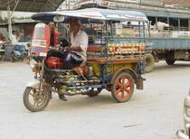 Am 05.07.2009 steht am Busbahnhof in Lamplaimat (Thailand) dieses Suzuki Motorrad, das zu einem Motorradtaxi umgebaut wurde und wartet auf mit dem Bus ankommende Fahrgste fr den Weitertransport