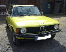 BMW E21 316, produziert von 1975 bis 1982. Die Baureihe E21, auch 3´er Reihe genannt, war das Nachfolgemodell des erfolgreichen BMW-02. Wie bei den Münchenern üblich, gab es eine breite Palette an Motorisierungen. Bei dem abgelichteten Fahrzeug im Farbton golfgelb aus dem Jahr 1979, handelt es sich um das damalige Basismodell 316. Die Modelle 315 (lieferbar ab 1981), 316 und 318 waren äußerlich an den einzelnen, vorderen Scheinwerfern zu erkennen. Die Sechszylindermodelle 320, 320i und später 323i waren mit Doppelscheinwerfern ausgestattet. Angetrieben wird dieser 316 von einem Vierzylinderreihenmotor, der aus einem Hubraum von 1573 cm³ 90 PS leistet. Die Höchstgeschwindigkeit gab das Werk, je nach Baujahr zwischen 160 km/h und 163 km/h an. 16. Oldtimer-Festival an der  Alten Dreherei  in Mülheim an der Ruhr am 16.06.2024.