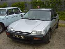 Honda Civic MK4 Stufenhecklimousine aus dem Jahr 1989. Die vierte Generation des Honda Civic stand ab 1987 bei den Händlern. Das Modell war als zweitürige Steilheck-Limousine, viertürige Stufenheck-Limousine, allradangetriebenes Kombi mit Hochdach, sowie als Sportcoupe namens CRX lieferbar. Der Kunde konnte zwischen etlichen Motorisierungen wählen. Der gezeigte Wagen ist mit dem stärksten, damals lieferbaren Motor ausgestattet. Der Vierzylinderreihenmotor hat einen Hubraum von 1590 cm³ und leistet 130 PS bzw. 124 PS PS, wenn ein Katalysator verbaut war. Eine solche viertürige Limousine kostete mindestens DM 24.290,00. 16. Oldtimer-Festival an der  Alten Dreherei  in Mülheim an der Ruhr am 16.06.2024.