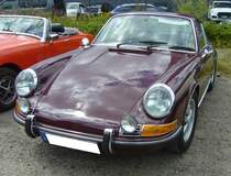 Porsche 911 T aus dem Jahr 1968. Der Porsche 911 T kam Ende 1967 als dritte und preisgünstigste Modellvariante der Typenreihe 911 auf den Markt. Vor allem die Angst der Zuffenhausener vor dem preisgünstigen Fiat Dino soll sein Erscheinen beschleunigt haben. Die Angst war unbegründet, wie sich hinterher herausstellte, doch nun war der 911 T mit einem Listenpreis von rund DM 19.000,00 auf dem Markt und erwies sich als unerwarteter Verkaufsschlager. 1968 hatte Porsche den Preis auf DM 19.305,00 erhöht, aber der 911 T blieb immer noch das interessanteste Angebot in der 911´er Palette. Der im Heck verbaute Vierzylinderboxermotor dieses burgunderroten 911 T hat einen Hubraum von 1991 cm³ und leistet zwischen 100 PS und 110 PS. 16. Oldtimer-Festival an der  Alten Dreherei  in Mülheim an der Ruhr am 15.06.2024.
