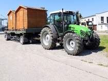 DEUTZ-FAHR Agroplus-95 transportiert am mitgeführten Anhänger 2Schaubuden; 240625