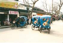 Im Februar 2003 warten in der chinesischen Stadt Suzhou diese Fahrradrikschas, die billigsten Taxen in der Stadt, auf Fahrgste.