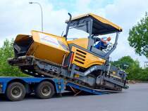 Ein 20 to. schwerer Vgele Super 1800-2 Asphaltfertiger wird mit viel Gefhl von dem Tieflader geladen. Mit der Maschine lassen sich bis 700 to. Asphalt pro Stunde einbauen, die Arbeitsbreite ist maximal 8,5 meter.