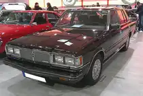 Toyota Crown Super Saloon der Baureihe MS112 aus dem Jahr 1980. Das Oberklassemodell aus dem Hause Toyota wurde von 1980 bis 1983 auch in Deutschland und Österreich angeboten. Mit seinen Außenmaßen und seiner üppigen Ausstattung machte der Wagen etwas her. Das der für den US-Geschmack gestylte Wagen sich auch hierzulande einiger Beliebtheit erfreute, lag an seinem sensationell günstigen Preis und der sehr umfangreichen Serienausstattung. Das Modell war auch als Kombiversion, mit 2200 mm langer Ladefläche lieferbar. Der Sechsylinderreihenmotor mit einem Hubraum von 2758 cm³ war mit 145 PS oder 170 PS lieferbar. Toyota Collection Köln am 07.06.2025.