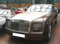 Rolls Royce Phantom VII Drophead Coupe aus dem Jahr 2009 im Farbton new sable. Gebaut wurde das Modell von 2003 bis 2017 im Werk Goodwood/Südengland. Da BMW seit dem Jahr 1998 die Markenrechte an Rolls Royce hält ist, der V12-Motor des Phantom VII auch eine BMW-Entwicklung. Der  Zwölfender  hat einen Hubraum von 6749 cm³ und leistet 460 PS. Bei einer Geschwindigkeit von 240 km/h regelt der Motor automatisch ab. Classic Remise Düsseldorf am 09.06.2025.