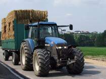 NEW HOLLAND-8160 zieht einen mit Strohballen beladenen Wagen Richtung Scheune; 090802