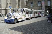 Diese Strassen-Eisenbahn hielt am 23.07.2009 neben der Kathedrale von Quimper in der Bretagne. Die Zugmaschine ist dekoriert mit Mustern von Faiencen. Diese Industrie ist in Quimper angesiedelt.