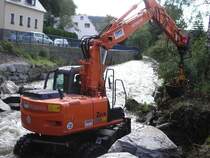 Hitatchi 130W beim Entfernen eines Wurtzelstockes auf der Wasserbaustelle.