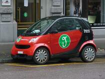 Roter Smart mit Werbung in der Stadt Fribourg am 09.11.2009