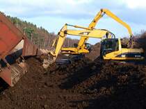 Mit zwei Caterpillarbagger, M318C und M325C wird ein Zug entladen in dem die Ladung festgefroren ist