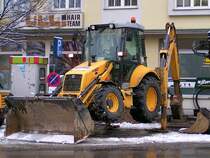 NEW-HOLLAND_B110 arbeitet sich in Ried i.I. in den Winterlichen Boden;091221