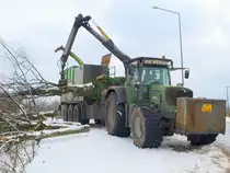 Hier wird geklotzt und nicht gekleckert, wenn es darum geht Platz fr den neuen RWTH Campus Melaten zu schaffen. Mit einem Fend Vario 930 an einem 3achser 600PS starken Hchsler (Heavy Herman) werden die Reste eines Wldchens hinter dem Aachener Klinikum gehchselt und entsorgt. An dem Hchsler ist ein Greifarm, mit dem der Fahrer des Traktors ganze Bume bis 50cm Stammdurchmesser in die Maschine stopft, die dann gehchselt werden und dann in dem Bunker am Fahrzeug zwischengelagert  werden. Wenn der Bunker voll ist wird in einen Abrollcontainer umgeblasen. Allein dafr wird vom Traktor 120 PS ber die Zapfwelle bentigt. Gesehen am 01.02.2010 an der Melatenerstrasse in Aachen.