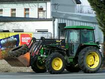 JohnDeere transportiert auf seiner Laderschaufel einen Traktorreifen;100223