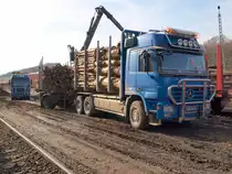 Actros 3355 Holztransporter als H�ngerzug mit Ladekran und im Hintergrund Actros 3354 Sattelauflieger beim beladen von Waggons in Stolberg am 24.03.2010. 