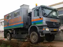 Diesen Actros mit Raupenantrieb einer Niederl�ndischen Firma konnte ich am 26.03.2010 in Aachen fotografieren. Das 20to. schwere Fahrzeug kann mit hydraulischen Stempeln den Raupenantrieb nach unten dr�cken um im schweren Gel�nde auf den Ketten zu fahren oder wie hier zu sehen den Lkw bei seiner Arbeit zu stabilisieren. In dem Aufbau befindet sich eine hydraulische Vorrichtung mit der eine Sonde in den Untergrund gedr�ckt wird um die geologische beschaffenheit des Bodens z.b. bei Bauvorhaben zu pr�fen. Der Faltenbalg auf dem Aufbau wird nur bei den Untersuchungen hochgeschoben um das Bohrgest�nge im Fahrzeug verl�ngern zu k�nnen (jeweils 1m lang). Hier wurde die Sonde ca. 18m tief gedr�ckt, wobei zum Teil ca. 13to. Druck ausge�bt werden mu�.
