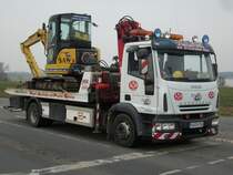 IVECO-Abschlepper mit einem defekten Minibagger auf der Ladeflche am 26.Mrz 2010 an einer Kreuzung bei Bergen/Rgen.