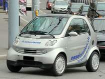 Grauer Smart mit Werbung unterwegs in der Stadt Lausanne am 27.03.2010