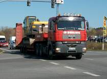 MAN-Schwerlasttransporter mit einem Bagger auf der Ladeflche am 15.April 2010 beim berqueren einer Kreuzung in Bergen/Rgen.