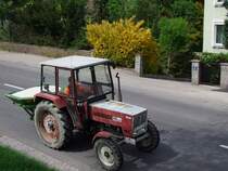 STEYR768 ist mit voll beladenem Kunstdngerstreuer Richtung Feld unterwegs;100430