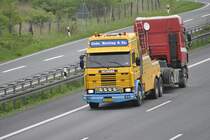 Dieser Auslndischer Scania R 145, hat ein Defeckten LKW am Hacken, auf der A2 bei Lehrte/Niedersachen, am 11.05.2010.