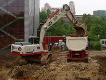 Ein Liebherr 934 Litronic Bagger beld am 01.06.2010 einen MAN TGS 18.480 mit Muldenauflieger auf einer Baustelle der RWTH Aachen in der Nhe des Klinikums.