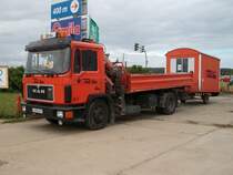 MAN-Kipper mit einem Bauwagen am 30.Juli 2010 auf einem Parkplatz in Bergen/Rgen.