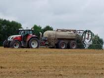 STEYR6175CVT bringt vor der herannahenden Regenfront noch Glle auf das abgeerntete Weizenfeld;100813