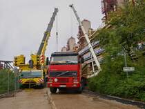Volvo FH16 520 mit 4achsen am 18.08.2010 an der Grobaustelle am Aachener Klinikum. Im Hintergrund 2 Terx Autokrne die ein groes Betonfertigteil in die richtige Position hehen. Hier wird ein 15m hoher freitragender Hubschrauberlandeplatz fr zwei Hubschrauber vor dem Klinikum gebaut der ein bisschen an Raumschiff Enterprise erinnert. In Aachen wird er  die Hand Gottes  genannt.