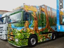 Der DINOSAURIER-TRUCK, ein Actros 1844 der Spedition Schumacher aus Würselen bei Aachen. Leider war der Lkw zugeparkt, auf der Fahrerseite ist ein eindrucksvoller T-Rex auf dem Kühlauflieger zu sehen. Diesen Kühlzug gab es von Herpa auch als Modell im Maßstab 1:87. Die Fachspedition für Kühltransporte hat einen sehr jungen Fahrzeugpark von ca. 85 Fahrzeugen und ist Europaweit mit ihren zum Teil aufwendig lackierten Lkw`s unterwegs. Aufnahme vom 22.08.2010.