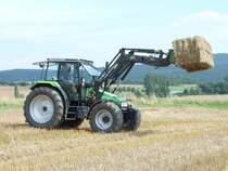 Deutz-Fahr Agroxtra 4.57 mit Baas Trima - Frontlader beldt einen bereitgestellten Anhnger mit Strohballen, August 2010