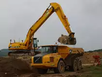 Kobelco SK 330 LC-6 Long Stick bel�d einen Volvo Dumper A30 D am 09.09.2010 an der Campusbaustelle der RWTH in Aachen Melaten mit Aushub. Beide Fahrzeuge sind von der Firma Leenaerts Born.