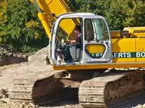 Der eine baggert, der andere passt auf. Diesen Tierischen Beifahrer konnte ich am 22.09.2010 auf der Campusbaustelle in Aachen auf einem Kobelco SK 330 LC-6 Long Stick von der Firma Leenaerts Born beobachten.