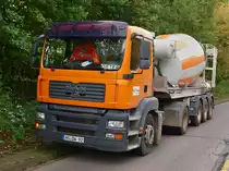 MAN TGA 18.440 mit 3achser Karrena Betonmischerauflieger wartet am 27.09.2010 an einer Baustelle in Aachen auf der Stiewistrasse.