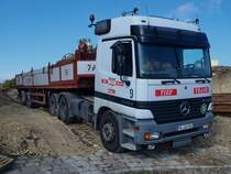 Ein Actros 3353 hat seinen fr eine Bohr-und Rammgertetragmaschine Bauer BG15H mit Bohrzubehr beladenen Sattelauflieger am 01.10.2010 auf eine Baustelle in Aachen auf der Pauwelstrasse geschoben.