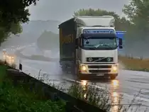 Volvo FH mit Planenauflieger am 19.10.2010 im str�menden Regen auf der A4 bei Aachen Richtung Niederl�ndische Grenze unterwegs.