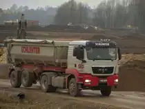 MAN TGS18.480 mit Kippersattelauflieger am 25.11.2010 auf der Campusbaustelle in Aachen. Der Fahrer hat gerade seine Ladung abgekippt und f�hrt nun mit gehobener Liftachse zur Ladestelle zur�ck.