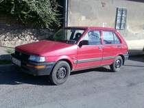Typischer japanischer Kleinwagen in einer typischen roten Farbe: Subaru Justy, foto: Oktober 2010.