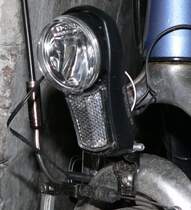 Fahrrder und Beleuchtung, ein kompliziertes Thema. So mssen im Straenverkehr fahrende Rder mit einer Dynamoanlage ausgestattet sein, es sei denn sie unterschreiten ein Gewicht von 11 kg. In diesem Falle ist eine stndig batteriebetriebene Beleuchtung zulssig.

Ein rgernis fr viele Radfahrer sind die jahrzehntealten STVZO-Vorschriften, die besagen, dass die Frontlampe nur 2,4 Watt und die Rcklampe nur 0,6 Watt aufnehmen drfen, bei 6 Volt Spannung. Die Zulassungspraxis machte bisher nicht den Eindruck, als ob wenigstens diese Kriterien auch nur ansatzweise erfllt werden mssten.

Glhlampen mit vorgeschriebener Leistung (bis 10 Lux) reichen gerade so, um gesehen zu werden (scherzweise spricht man von der Helligkeit einer brennenden Zigarette). Halogenlampen mit dieser Leistung (17 Lux) knnen bereits das Nahfeld ganz gut ausleuchten, auch ist ihre Lebensdauer erheblich hher (ca 100 Std. gegenber 10 Std. einer Glhlampe).

Einen Sonderfall stellen LED-Scheinwerfer dar. Leuchtquelle ist meist eine 1-Watt-LED (also keine 2,4 Watt), allerdings erhalten diese Scheinwerfer wegen ihrer Helligkeit (vorgeschrieben sind mindestens 10 Lux) trotzdem Prfzeichen und sind damit zulssig. 

Whrend bisherige Fabrikate eine Lichtstrke von ca. 16 Lux aufwiesen, hat die im Bild gezeigte Lumotec IQ Fly aus dem Hause Busch & Mller (www.bumm.de) eine sagenhafte Lichtstrke von 40 Lux. Nicht nur einmal wurde ich lobend angesprochen. Der Preis von 60-75 je nach Ausfhrung wird sich allerdings eher fr Viel-Radler lohnen.