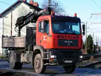 MAN-Kipper mit aufgebautem HIAB-Kran quert einen vielbefahrenen Bahn�bergang der Ostbahn;101123