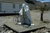 In Rhyolite, einer  Geisterstadt  in Nevada beim Death Valley schuf Ende der 1980er Jahre ein belgischer K�nstler Figuren aus geh�rtetem Acryl. Diese h�lt seitdem ein Fahrrad. (Juli 1992)