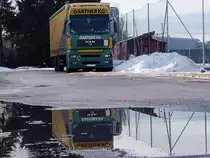 MAN TGA18.440 der Spedition Gartner spiegelt sich in einer Pf�tze;110108