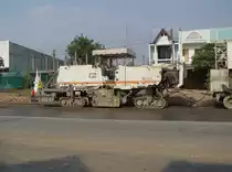 Diese Asphaltfrse Wirtgen W 2200 im Einsatz beim Straenbau bei Maha Sarakham im Nordosten Thailands am 11.02.2011