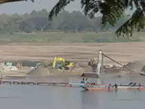 Komatsu Bagger und ein Radlader bei der Arbeit auf einer Sandbank im Mekong bei Nong Khai im Nordosten Thailands am 11.02.2011. Das jenseitige Ufer ist Laos.