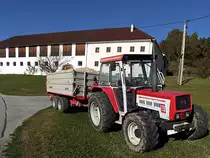 LINDNER-1750 steht mit einem Hackschnitzel beladenen Einachstandemkipper vor einem Mhlviertler Gehft;101029